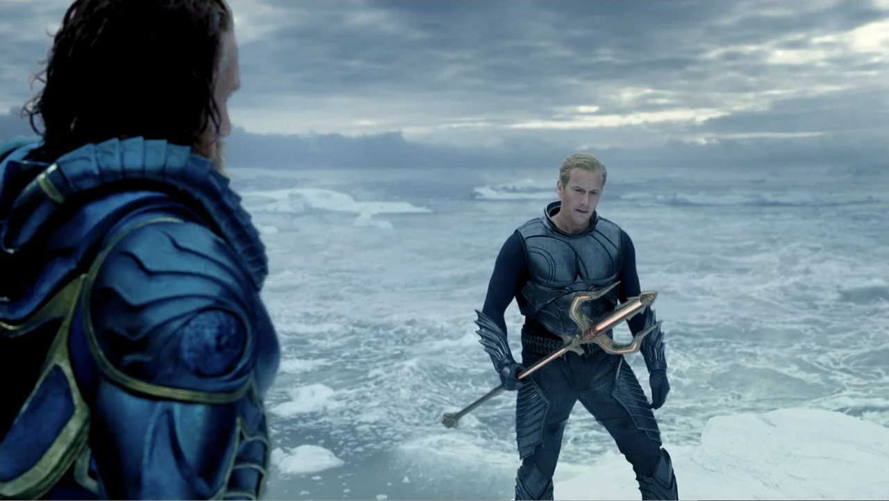 Aquaman and the Lost Kingdom (2023) movie still: medium — An arctic landscape features vast expanses of ice under a cloudy grey sky. A man in dark…