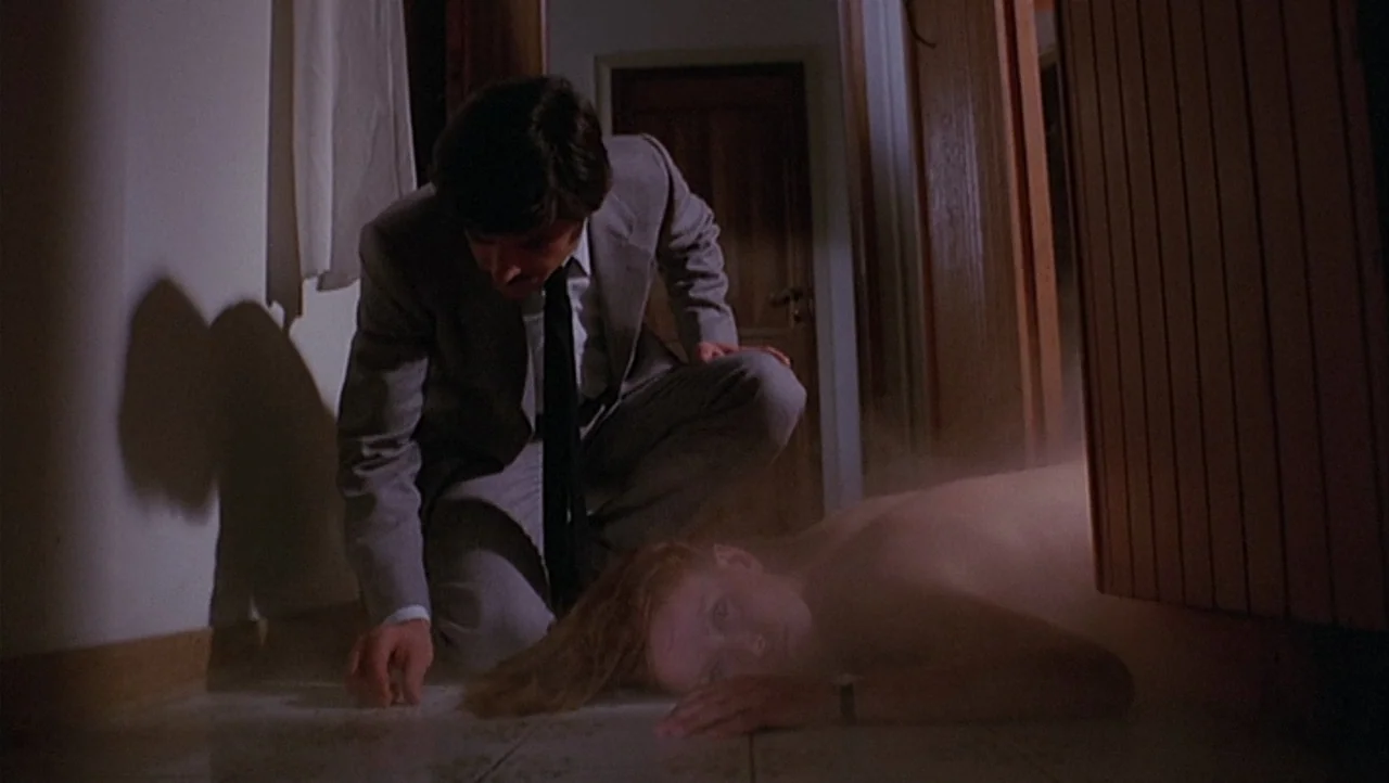 The Black Belly of the Tarantula (1971) movie still: medium — A dimly lit indoor residential hallway features wooden paneling and light-colored…