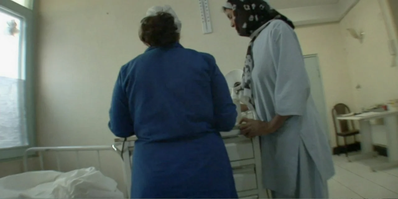Silencing the Song: An Afghan Fallen Star (2011) movie still: medium — A sparse hospital room contains a white medical cart and a metal bed frame.…