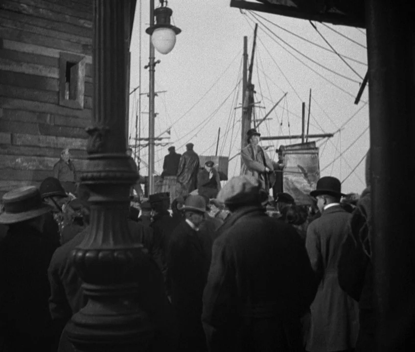 The Threepenny Opera (1931) movie still: wide — A crowded maritime scene with numerous people in 1940s attire standing on a ship deck. Tall masts…
