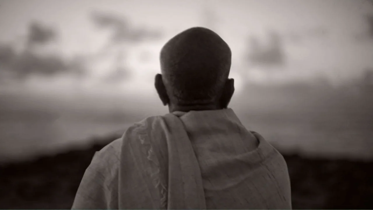 Hare Krishna! The Mantra, the Movement and the Swami Who Started It All (2017) movie still: medium — A dark rocky shoreline overlooks a vast ocean…