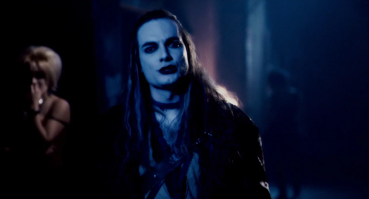 Repo! The Genetic Opera (2008) movie still: medium — A dark indoor space with cool blue light casting sharp shadows on the walls. A man with pale…