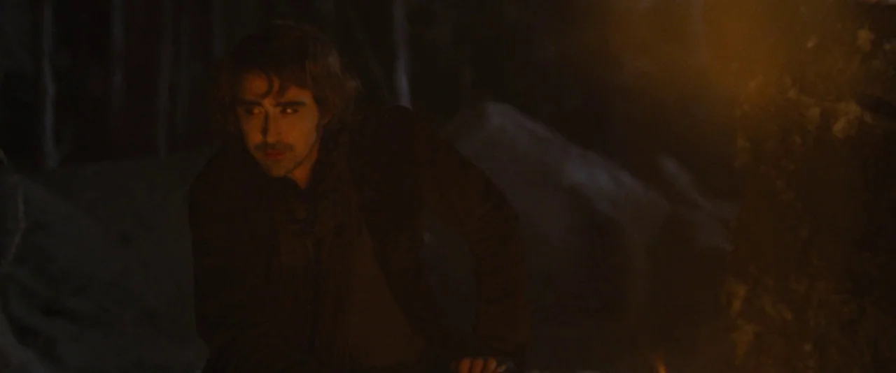 The Twilight Saga: Breaking Dawn – Part 2 (2012) movie still: medium — A dark outdoor space is illuminated by an off-screen campfire glowing to the…