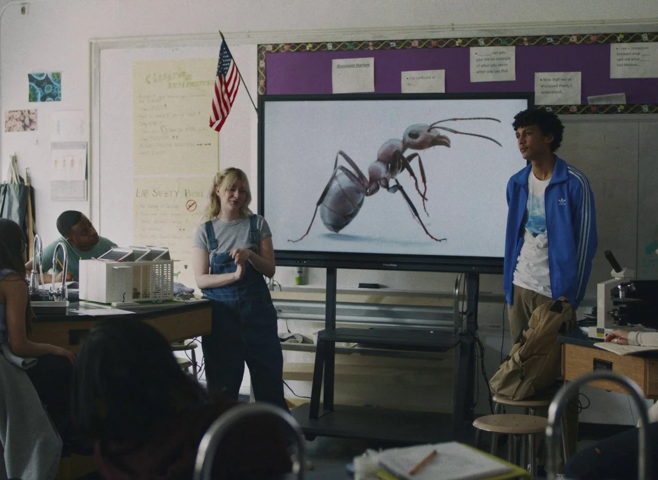 She Came To Me (2023) movie still: medium — A science classroom contains lab tables, microscopes, and a large digital screen display. Two students…