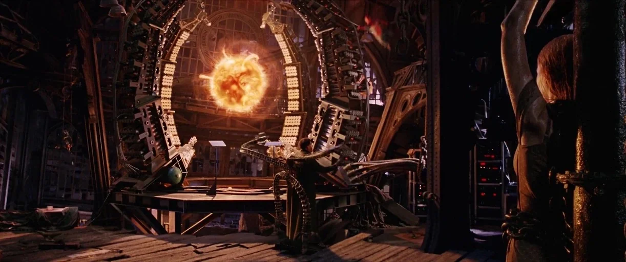 Spider-Man 2 (2004) movie still: wide — An industrial laboratory contains a large, circular fusion reactor emitting a bright orange glow. A male…