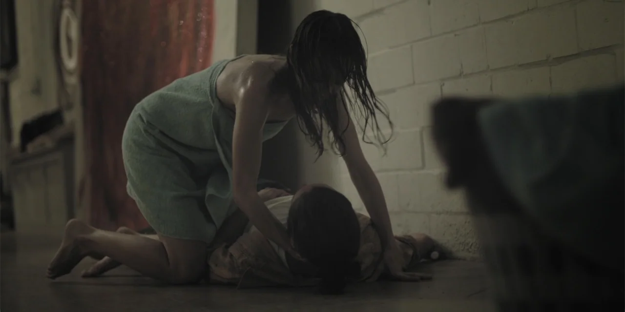 Stalked by My Doctor: A Sleepwalker's Nightmare (2019) movie still: medium — A utilitarian room with painted brick walls and a concrete floor. A…