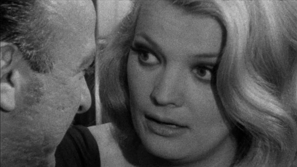 Faces (1968) movie still: closeup — An interior space features two people framed in a close-up conversation. A woman with blonde hair stares…
