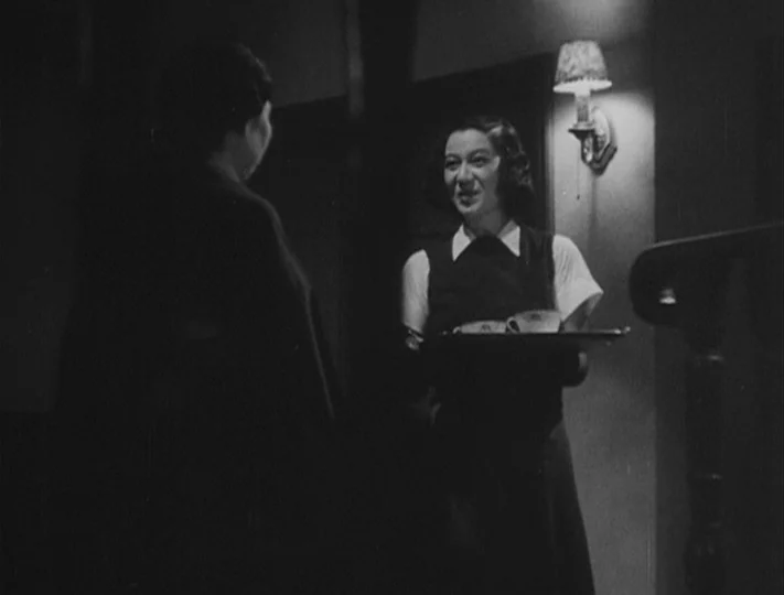 No Regrets for Our Youth (1946) movie still: medium — A dimly lit indoor passage featuring a wall-mounted sconce and a wooden staircase. A young…