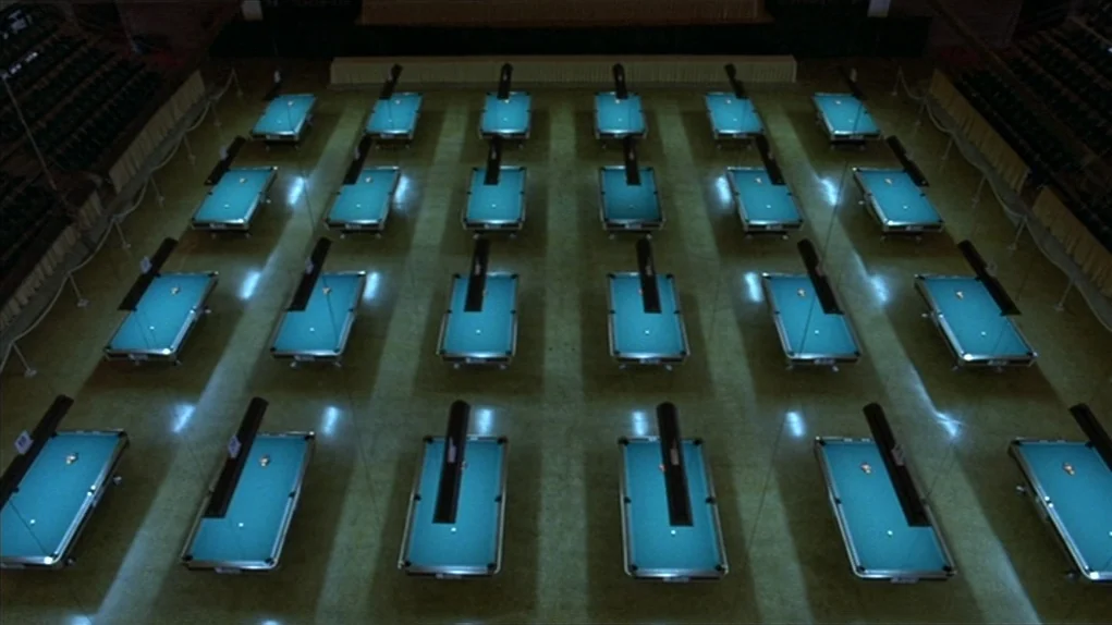 The Colour of Money (1986) movie still: establishing — A vast hall contains many rows of billiard tables arranged in perfect geometric formation.…
