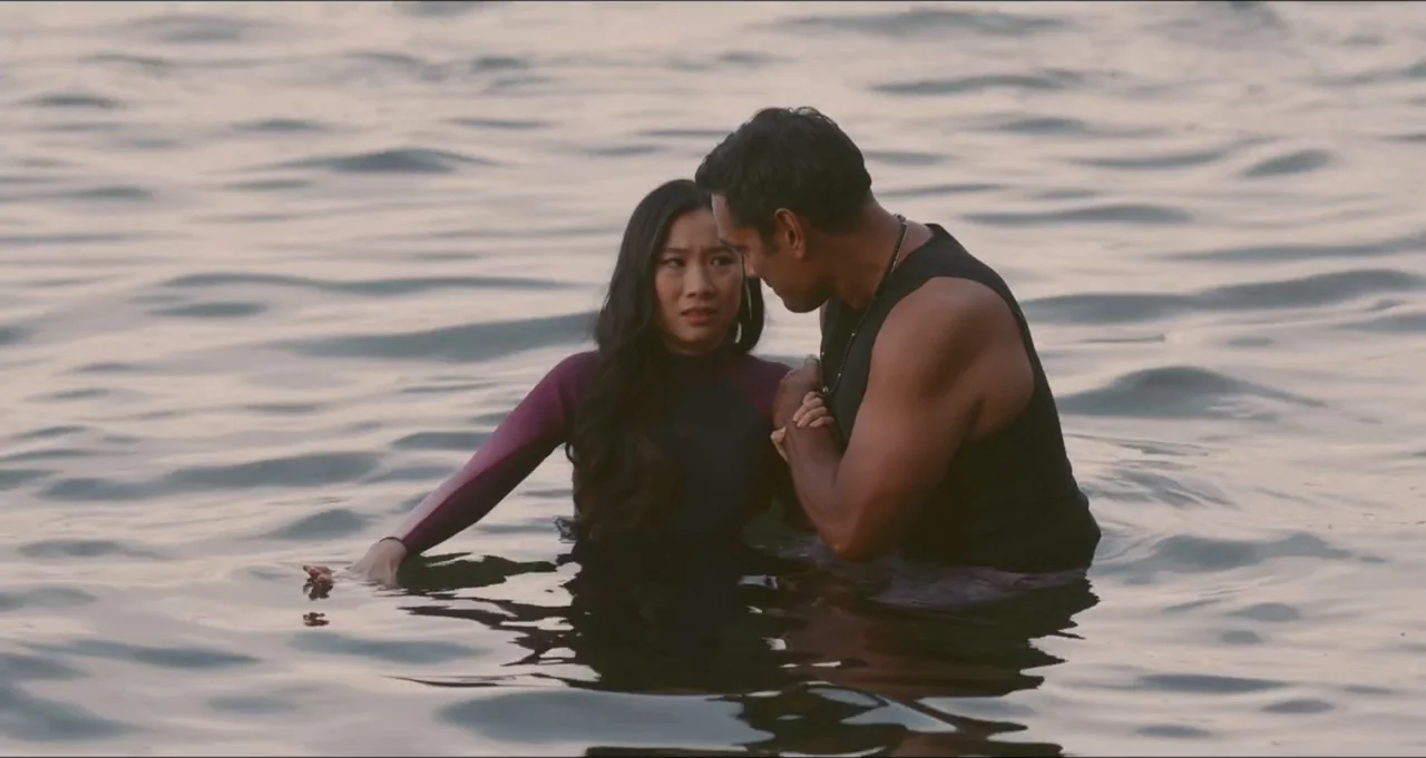 Five Blind Dates (2024) movie still: medium — A woman and a man stand together in calm, open water. The man grips the woman's arms while she looks…