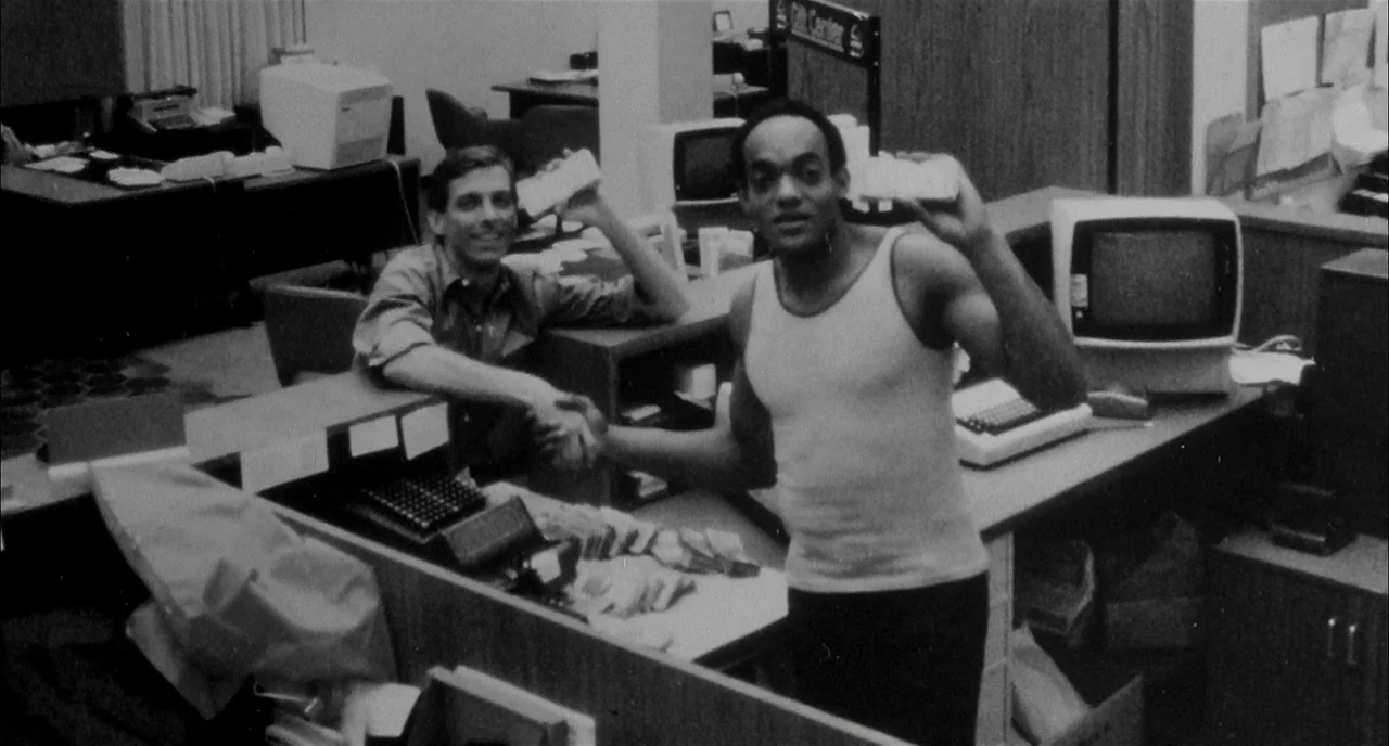 Dawn of the Dead (1978) movie still: medium — A department store service counter with vintage computers and paperwork scattered across desks. Two…