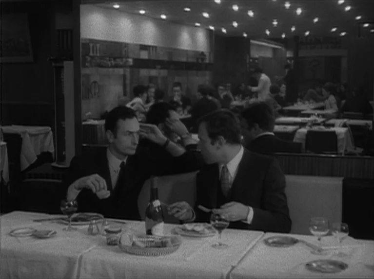 My Night At Maud’s (Ma Nuit Chez Maud) (1969) movie still: medium — A 1960s European restaurant with white tablecloths and a mirrored wall behind…