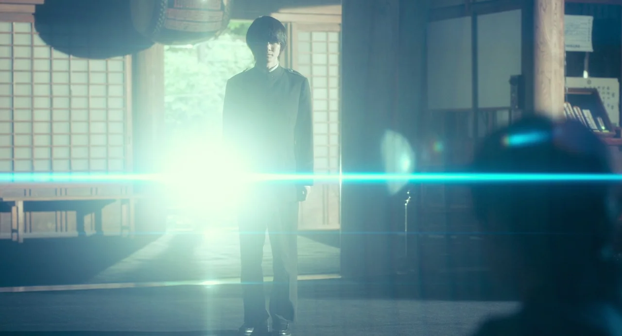 xxxHolic (2022) movie still: fullbody — A traditional Japanese shrine interior with wooden posts and shoji sliding doors in background. A young man…