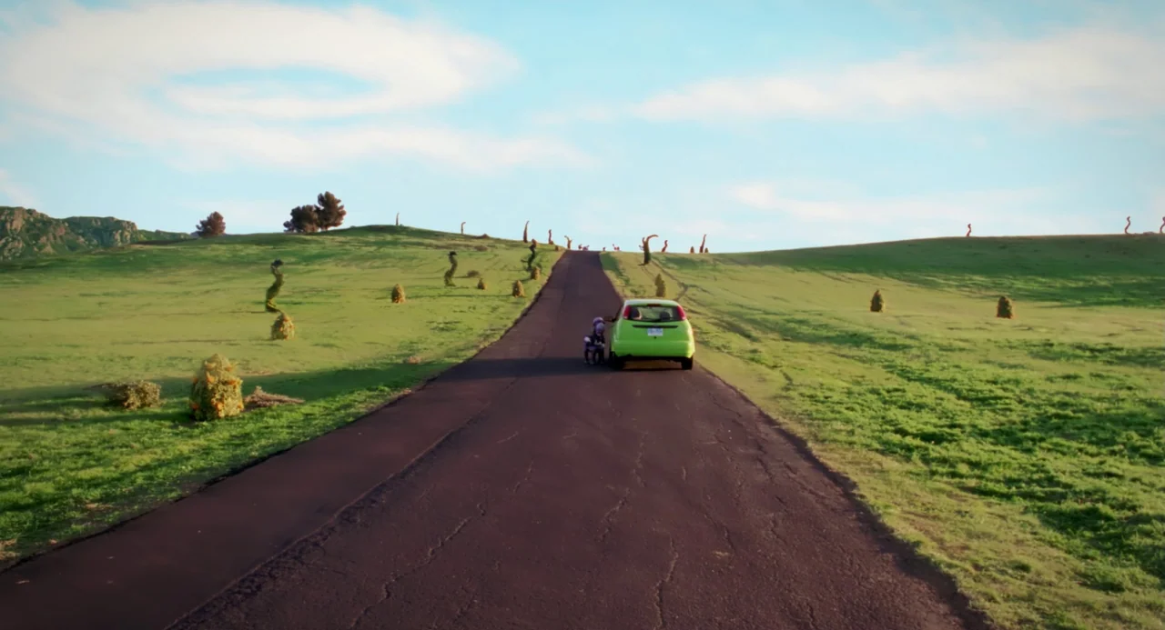 The Cat In The Hat (2003) movie still: wide — A lime green car is parked on a paved road cutting through rolling green hills. Sparse, strange…