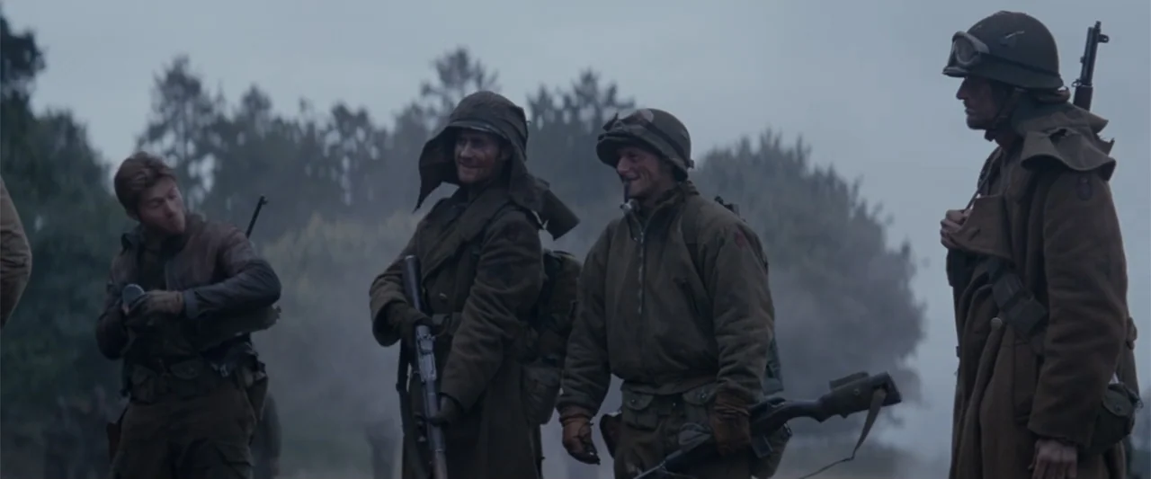 Fury (2014) movie still: fullbody — A foggy, open outdoor area with sparse trees visible in the soft gray background. Four soldiers dressed in…