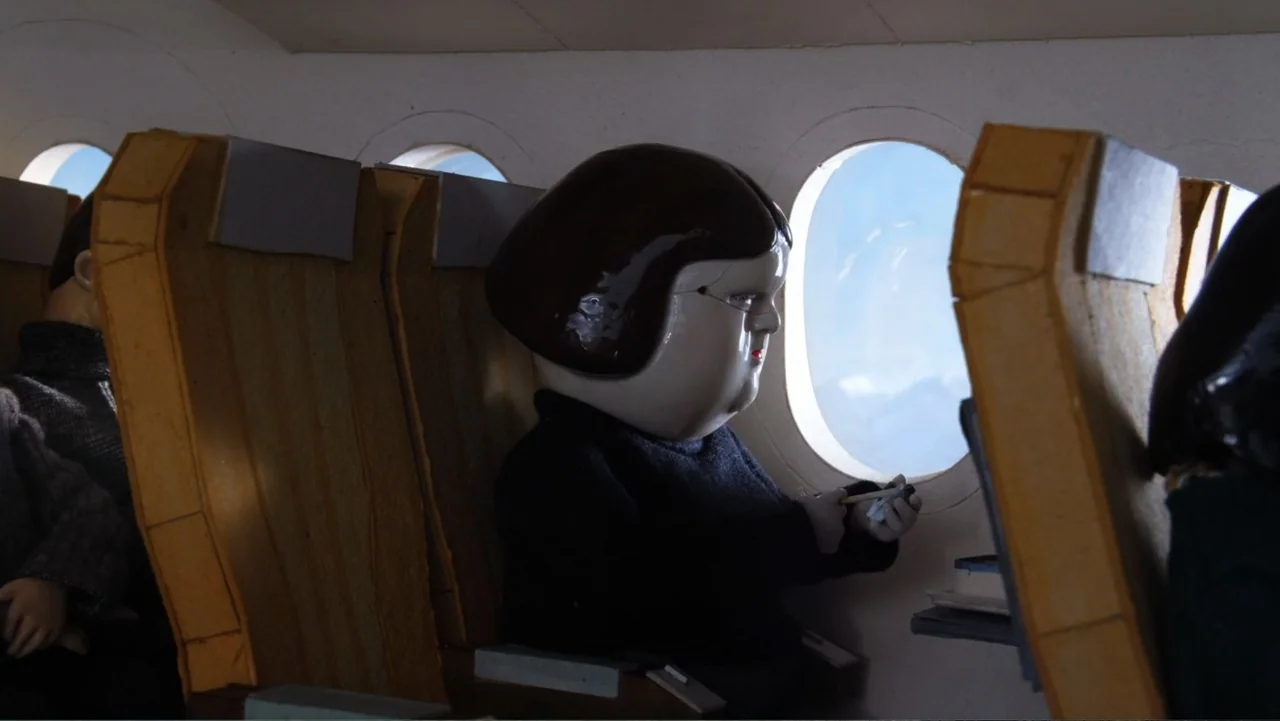 Bestia (2017) movie still: medium — An airplane cabin features rows of simple, boxy passenger seats made of wood and fabric. A stylized ceramic…