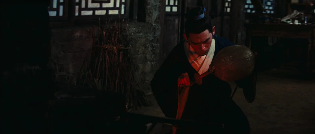 A Touch of Zen (1971) movie still: medium — A dimly lit workshop interior features rough brick walls and intricate wooden window lattice. A man…