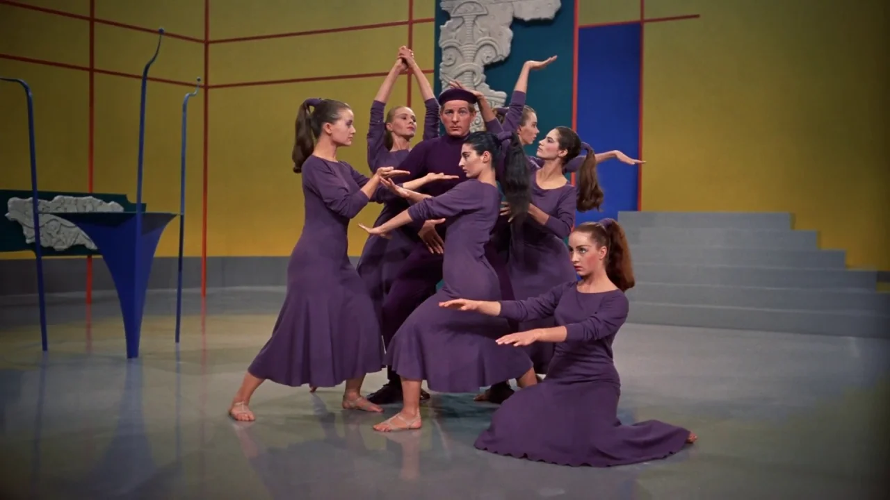 White Christmas (1954) movie still: fullbody — A theatrical stage with yellow walls and blue architectural geometric cutouts. A group of dancers…