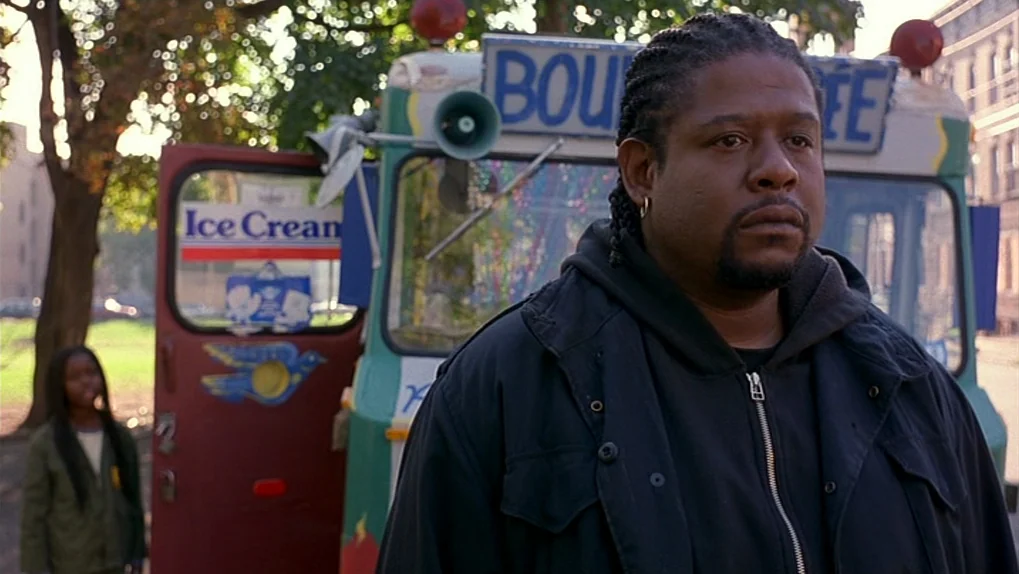 Ghost Dog: The Way of the Samurai (1999) movie still: medium — An ice cream truck is parked in a tree-lined outdoor setting during the day. A man…