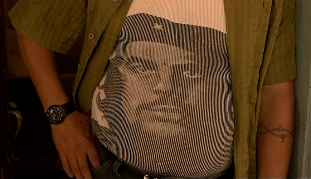 The Limey (1999) movie still: medium — The torso of a man wearing a shirt with a large portrait of Che Guevara. A black wristwatch and a barbed wire…