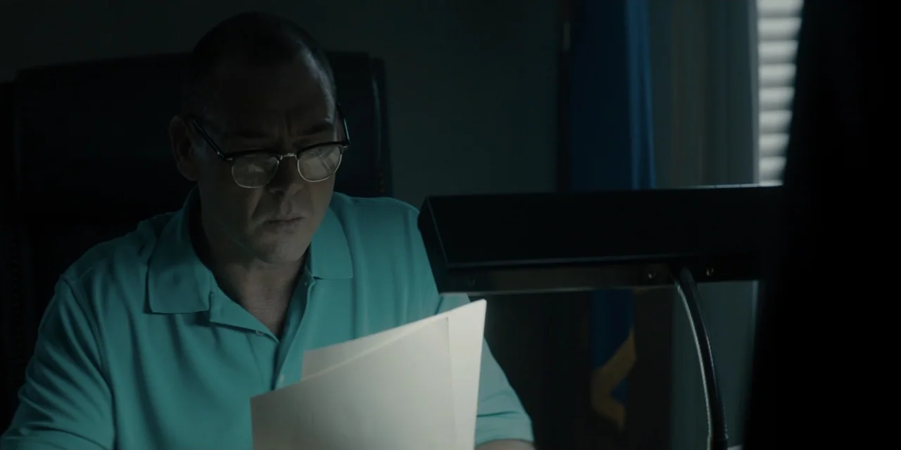 Mark Felt: The Man Who Brought Down the White House (2017) movie still: medium — A dimly lit office features a man working at a desk with a lamp. He…