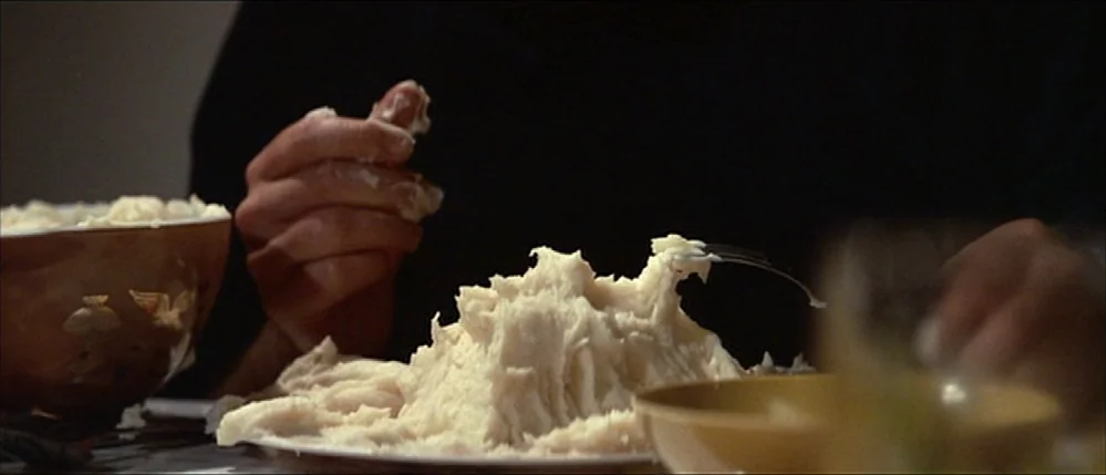 Close Encounters Of The Third Kind (1977) movie still: closeup — A dining table features a white plate piled high with sculpted mashed potatoes. A…