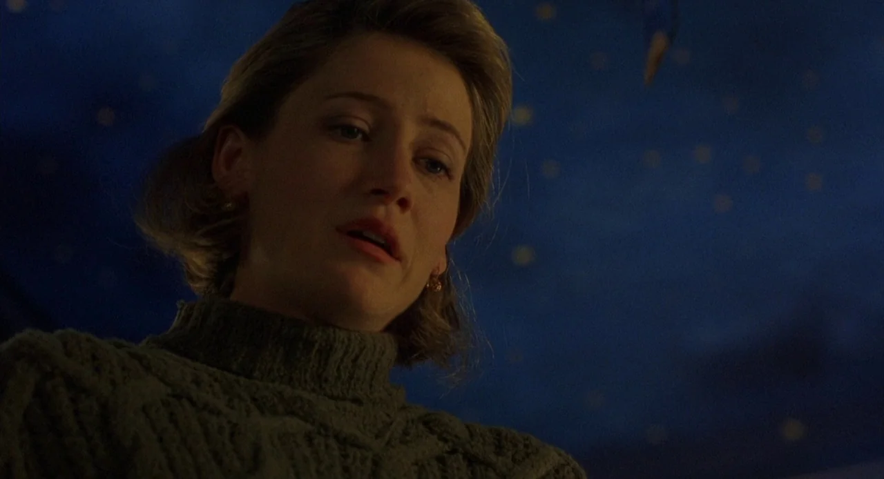 Candyman: Farewell to the Flesh (1995) movie still: closeup — A woman stands in a room with a dark blue ceiling decorated with stars. She gazes…