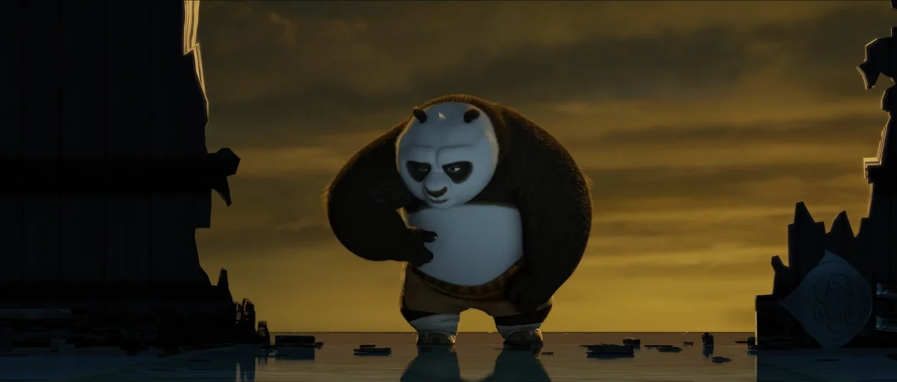 Kung Fu Panda (2008) movie still: medium — A ruined courtyard with debris and dark stone structures against a golden sky. An anthropomorphic panda…