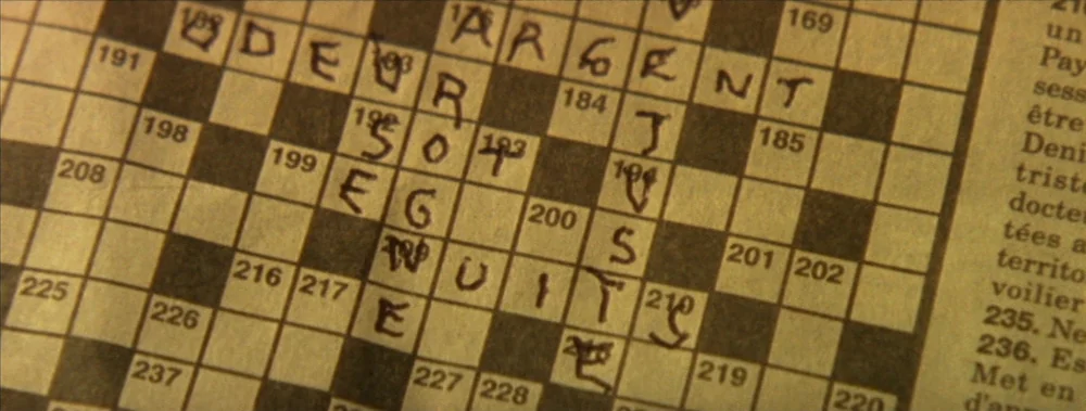 I Stand Alone (Seul Contre Tous) (1998) movie still: closeup — A close-up view of a partially filled-out crossword puzzle printed on old newsprint…