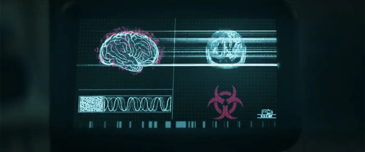 Ash (2025) movie still: closeup — A dark monitor displays a digital interface with analytical data and graphics. A glowing cyan brain model and red…