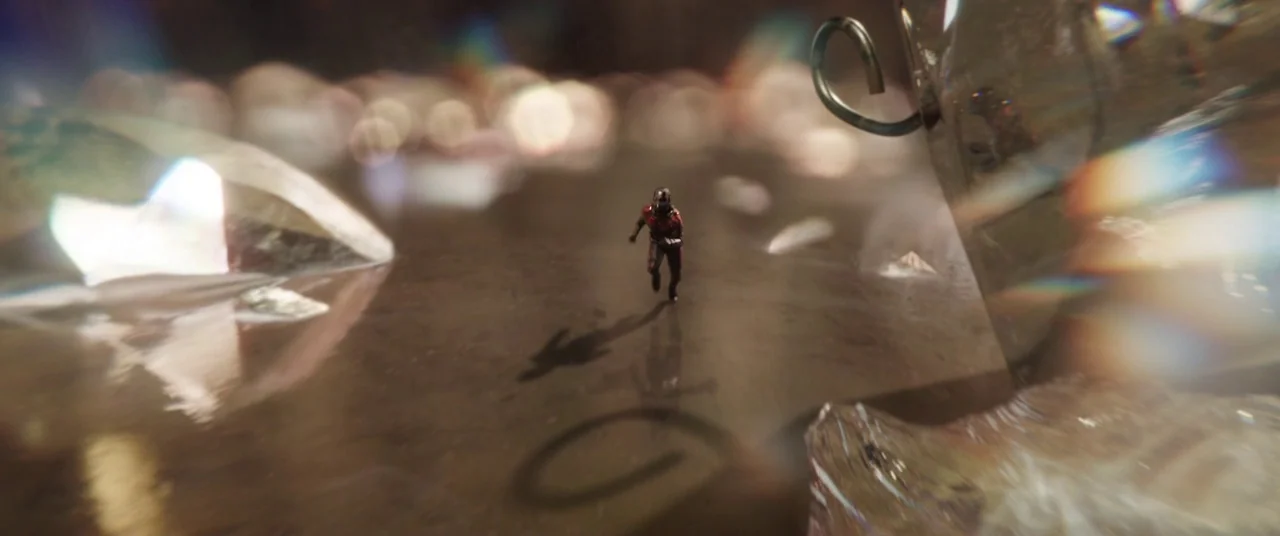 Ant-Man and the Wasp (2018) movie still: wide — A minuscule figure runs across a vast, smooth brownish surface next to large crystalline shards. A…