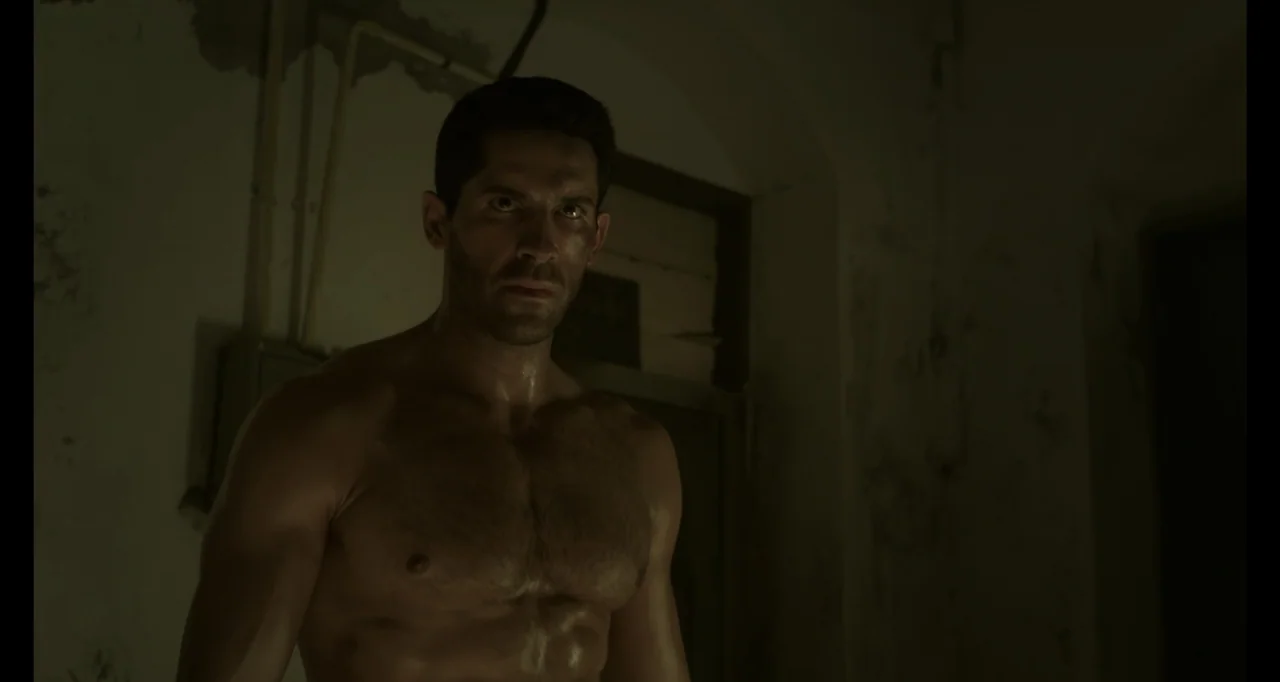 Ninja: Shadow of a Tear (2013) movie still: medium — A dark, spartan interior with textured concrete walls and faint electrical conduits above. A…