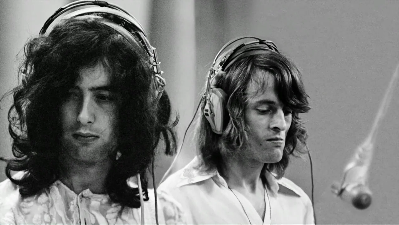 Becoming Led Zeppelin (2025) movie still: medium — A professional recording studio interior with clean white walls and acoustic treatment. Two…