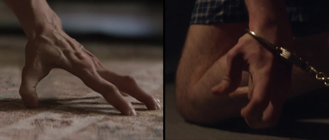 Suitable Flesh (2023) movie still: closeup — A split-screen shot displays two different perspectives of human hands on dark surfaces. One set of…