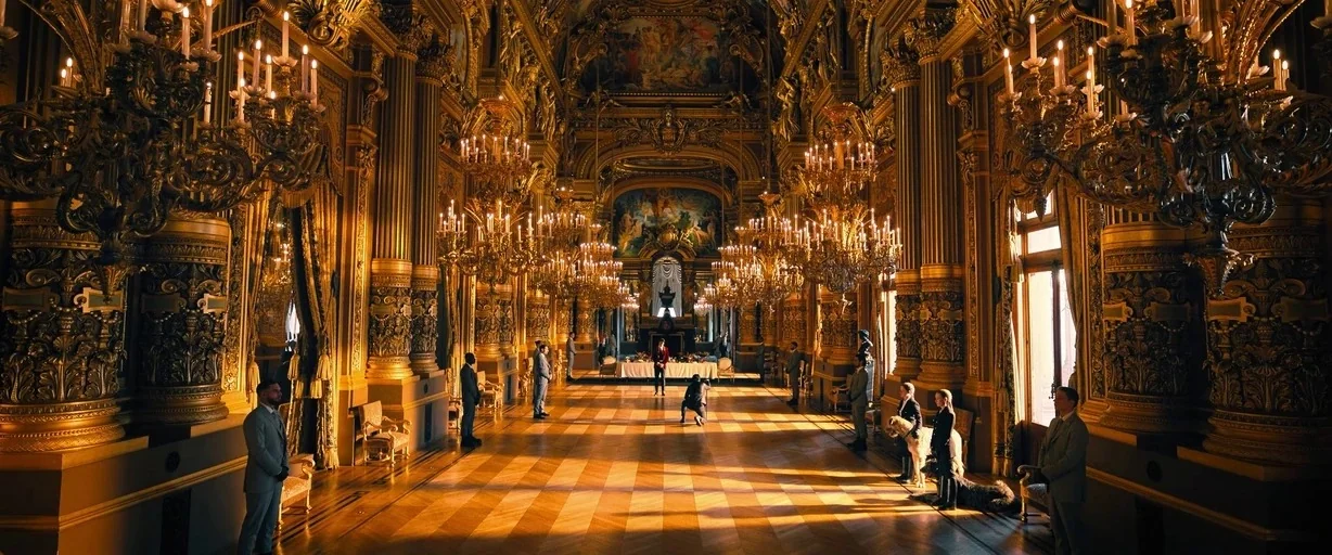 John Wick: Chapter 4 (2023) movie still: wide — A vast, opulent golden hall features ornate gilded columns and numerous hanging crystal chandeliers.…