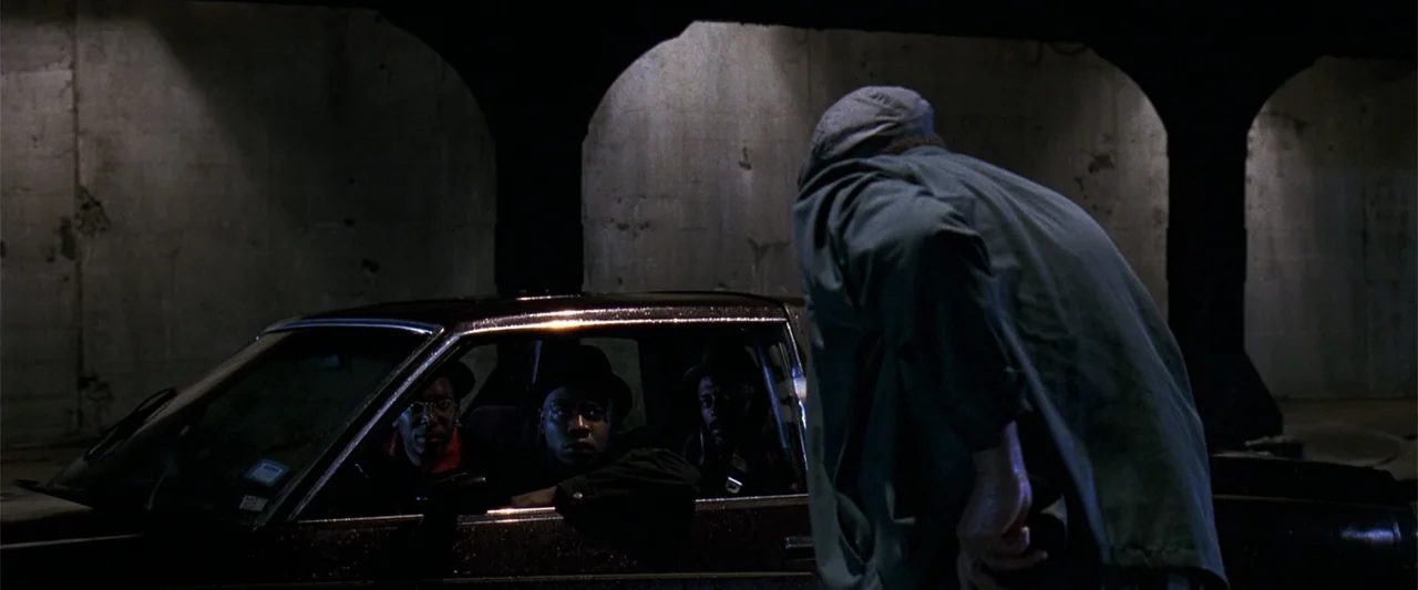 A Family Thing (1996) movie still: medium — A dark concrete underpass provides a backdrop for a car parked at night. A person in a green jacket…