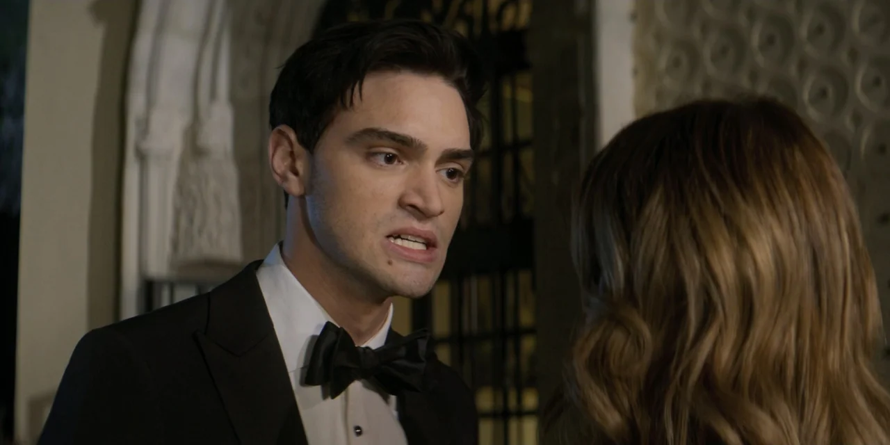 Your Fault (2024) movie still: medium — A dark outdoor space features an ornate stone archway in the background. A man in a tuxedo speaks directly…