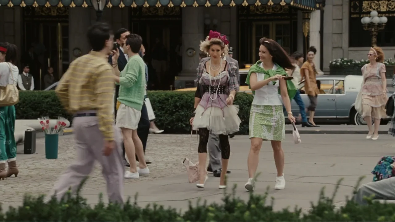 Sex and the City 2 (2010) movie still: fullbody — A public plaza in front of a grand building entrance with crowds of people. Two women walk…