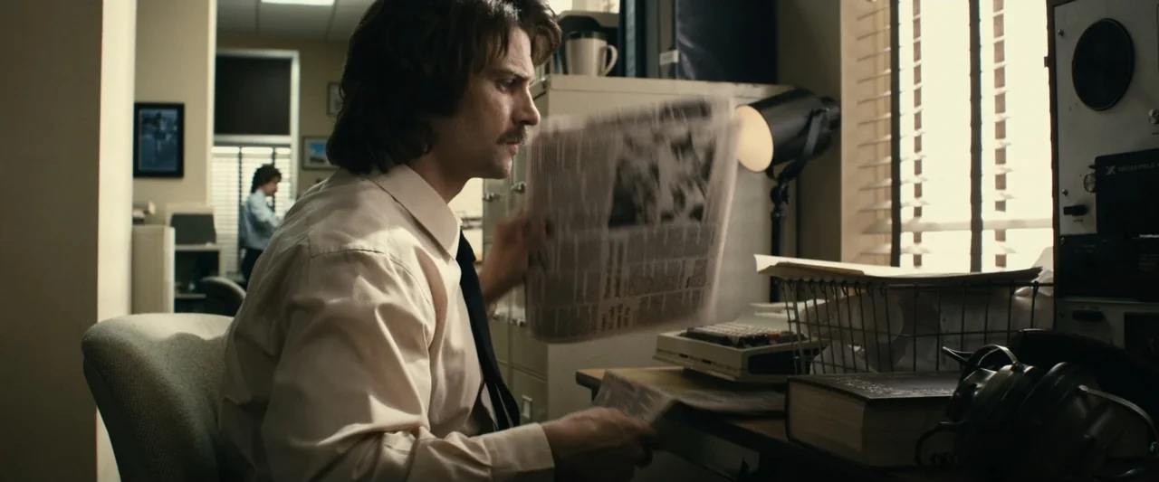 The Case for Christ (2017) movie still: medium — A 1970s style office features beige file cabinets, heavy books, and paper documents. A man sits at…