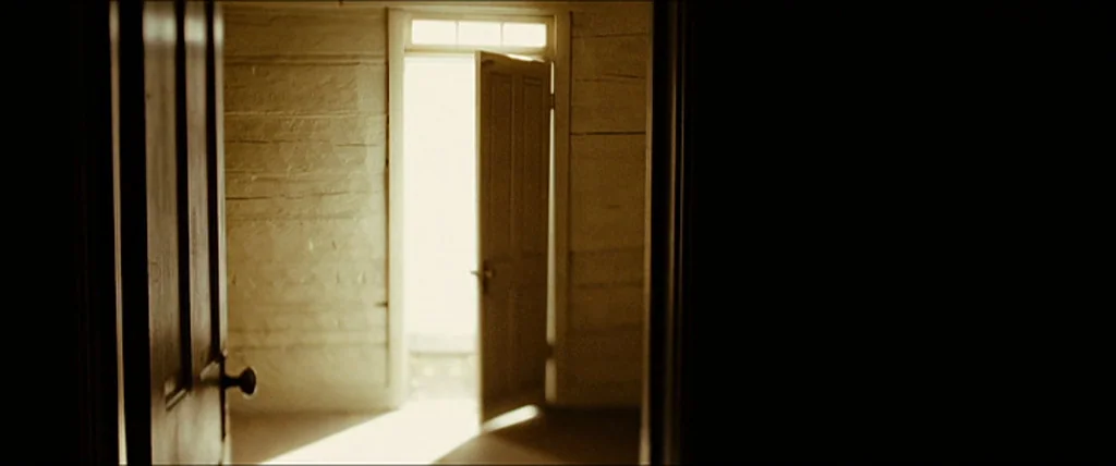 The Assassination Of Jesse James By The Coward Robert Ford (2007) movie still: establishing — An empty interior room features horizontal wood plank…