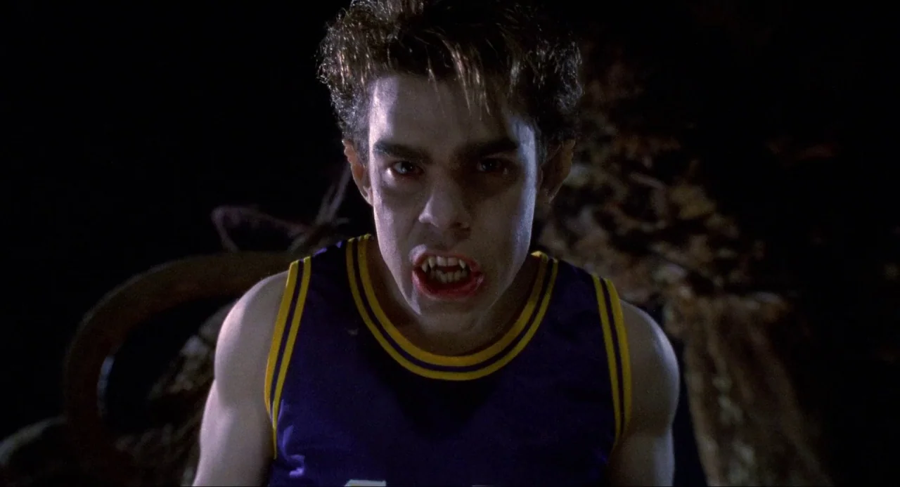 Buffy the Vampire Slayer (1992) movie still: closeup — A dark cemetery at night with blurred tombstones visible in the background. A young male…