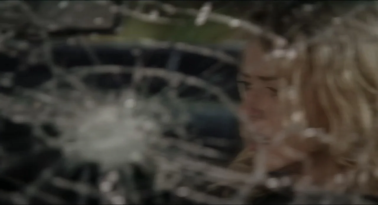 The Ring Two (2005) movie still: closeup — A view from inside a vehicle looking out through a spider-webbed, shattered windshield. A woman's blurry…