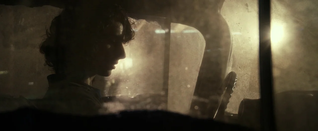 Ghostbusters: Afterlife (2021) movie still: medium — A dark car interior at night with a dusty, hazy windshield. A teenager is sitting in the…