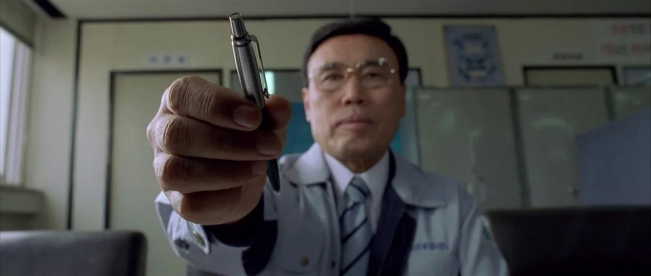 Sympathy for Mr. Vengeance (2002) movie still: medium — A bureaucratic room containing metal filing cabinets and wall-mounted documents under harsh…