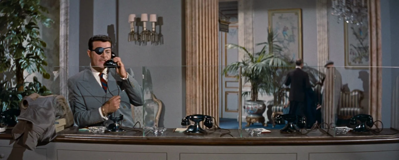 How to Marry a Millionaire movie still: medium — A refined interior with gray walls, decorative molding, and classical framed artwork on display. A…