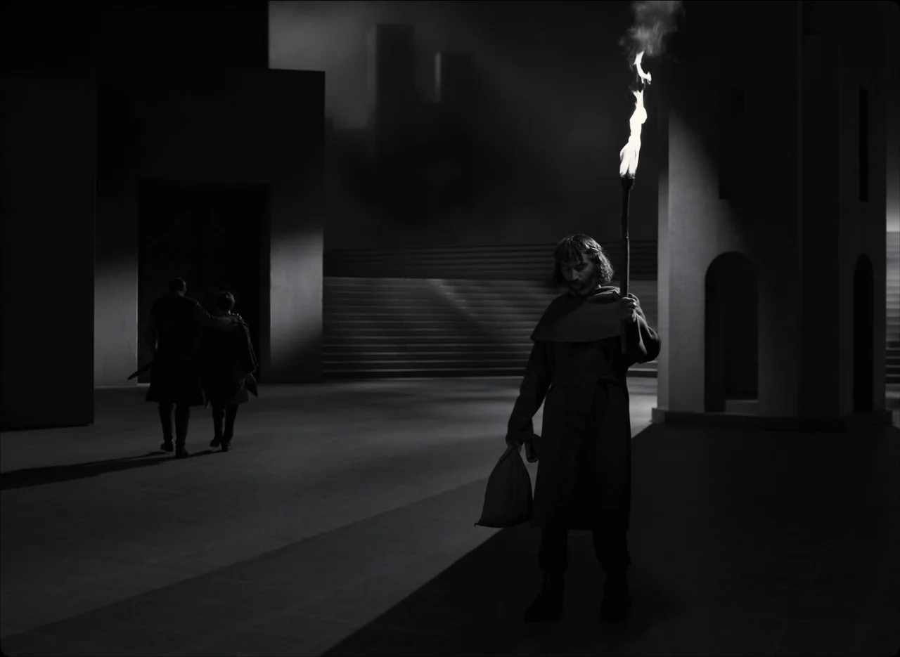 The Tragedy of Macbeth (2021) movie still: fullbody — A stark, minimalist stone courtyard at night features geometric architectural arches and…