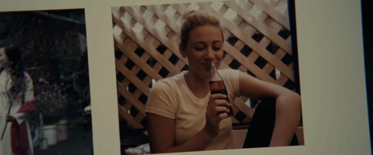 Chemical Hearts (2020) movie still: medium — A wooden lattice structure serves as a backdrop for a young woman sitting down. She holds a glass cola…