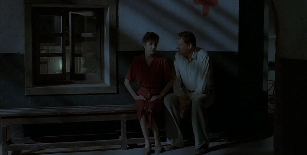 Dominion: Prequel to the Exorcist (2005) movie still: medium — A dimly lit hospital hallway features a red cross painted on the wall. A man and…