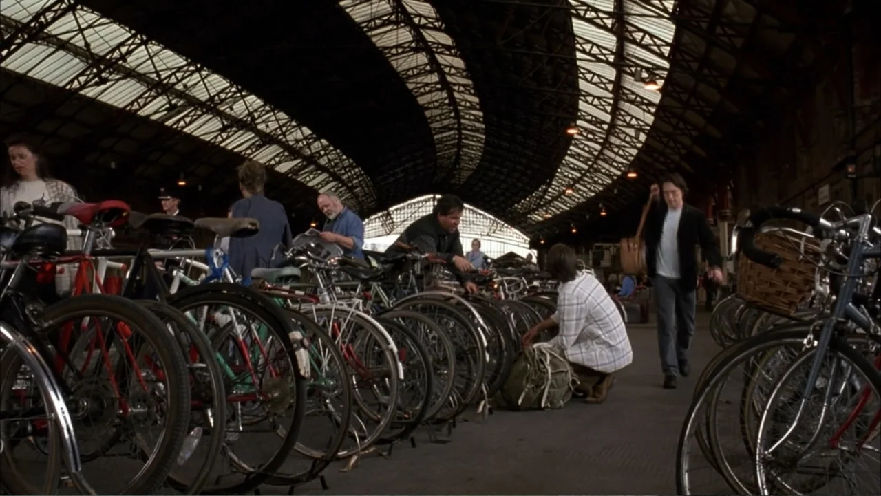 Starter for 10 (2006) movie still: wide — A busy train station terminal features an arched iron-frame glass roof and brick pillars. Several…