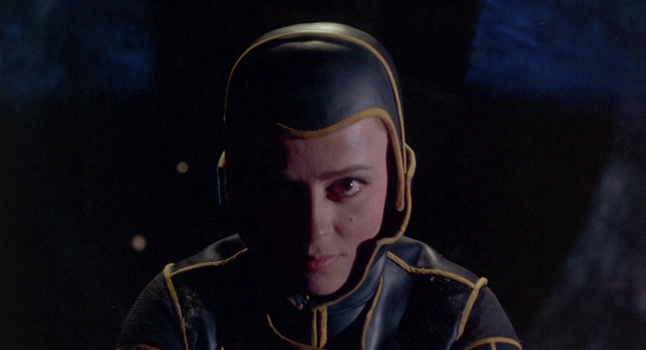 Planet of the Vampires (1965) movie still: closeup — A dark environment suggests the depths of water with no visible surroundings. A woman wears a…